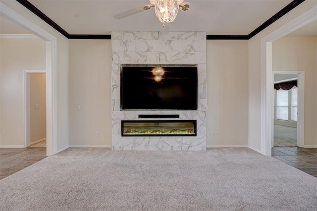 unfurnished living room with light carpet, ceiling fan, ornamental molding, and a premium fireplace