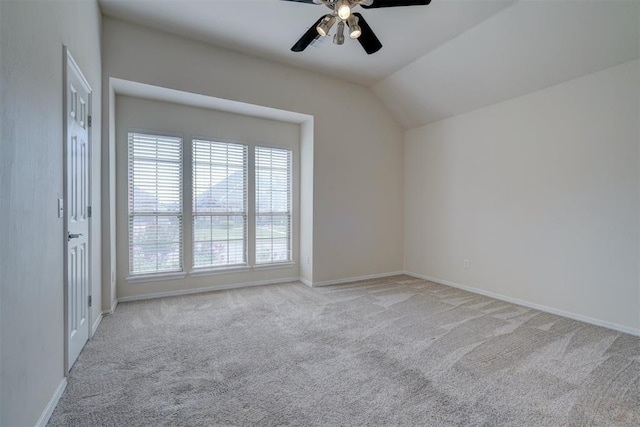 carpeted spare room with ceiling fan and lofted ceiling