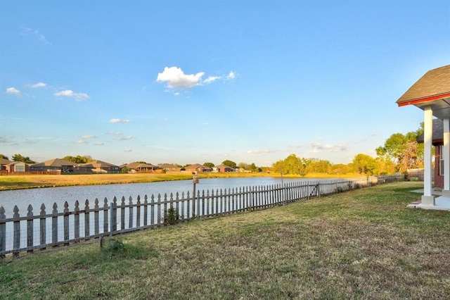 view of yard featuring a water view and fence