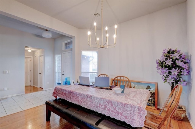 dining area featuring an inviting chandelier, baseboards, light tile patterned floors, and visible vents