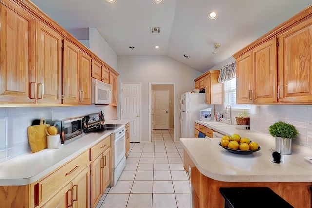 kitchen with light tile patterned floors, light countertops, a sink, white appliances, and a peninsula