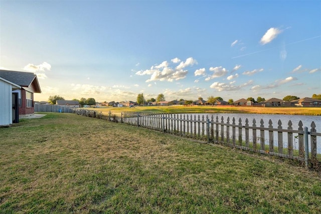 view of yard with a water view and fence