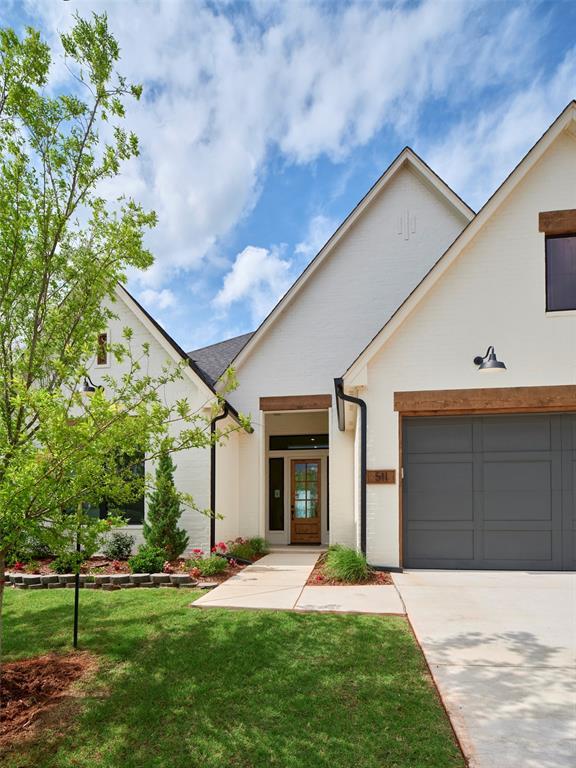 511 Basin Way, Norman, OK 73071 - view of front of home featuring a front yard, concrete driveway, and stucco siding