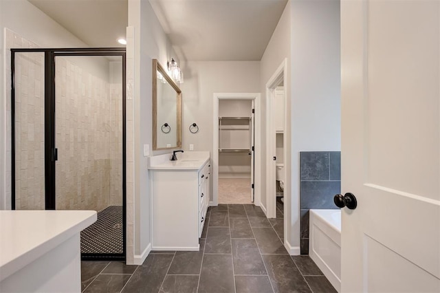 full bathroom with vanity, tile patterned flooring, a shower stall, a spacious closet, and a garden tub