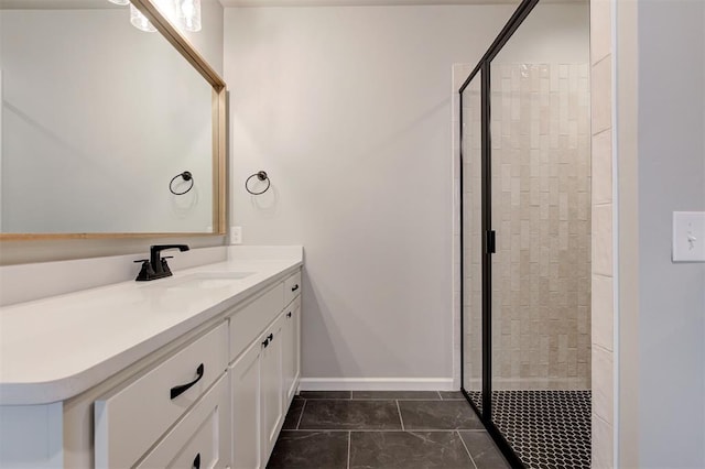 bathroom featuring baseboards, vanity, and a shower stall