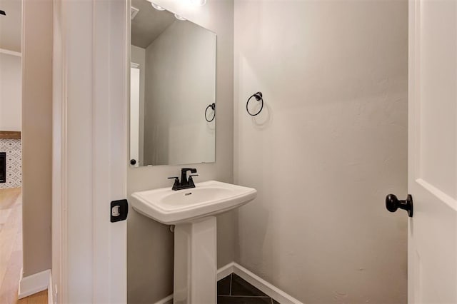 bathroom with a sink and baseboards