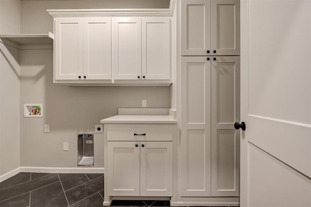 washroom featuring hookup for a washing machine, baseboards, hookup for an electric dryer, dark tile patterned flooring, and cabinet space