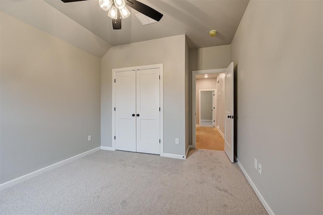 unfurnished bedroom with a closet, a ceiling fan, carpet, and baseboards