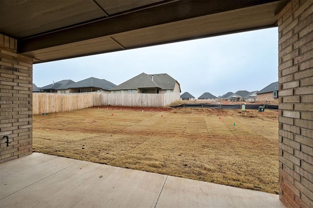 view of yard with a residential view, a patio, and fence