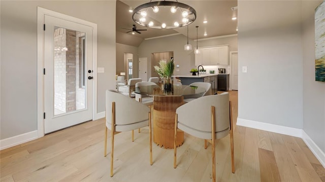 dining room with lofted ceiling, ceiling fan with notable chandelier, baseboards, and light wood finished floors