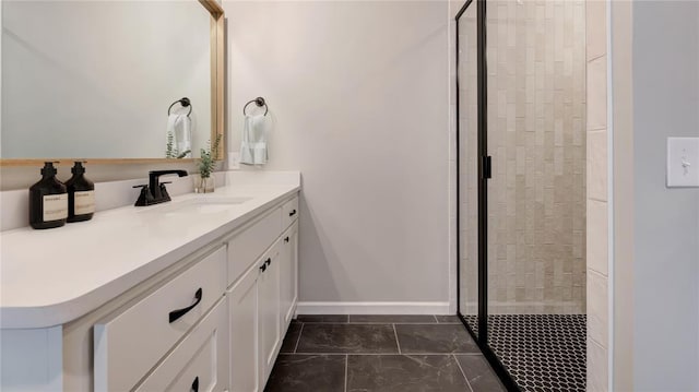 bathroom featuring vanity, baseboards, and a stall shower