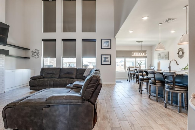 living room featuring a high ceiling and light hardwood / wood-style floors