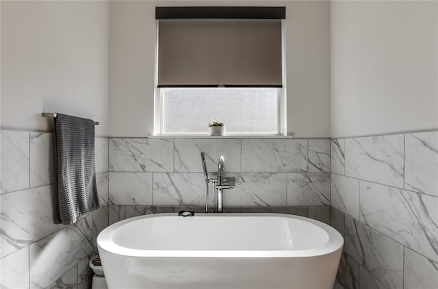 bathroom with a bathtub and tile walls