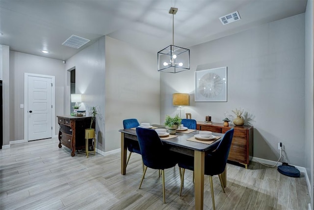 dining room featuring light hardwood / wood-style flooring and a notable chandelier