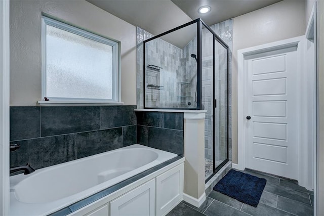 bathroom featuring tile patterned floors, tile walls, and independent shower and bath