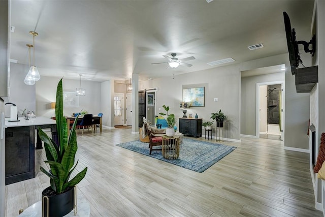 living room with ceiling fan and light hardwood / wood-style floors