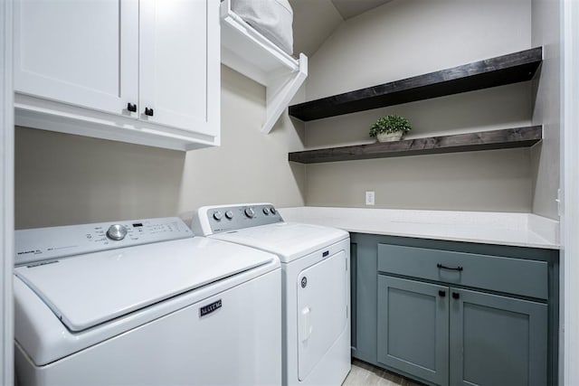 laundry room featuring cabinets, separate washer and dryer, and light hardwood / wood-style flooring