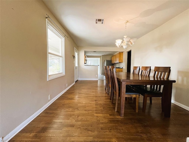 dining space featuring hardwood / wood-style floors and an inviting chandelier