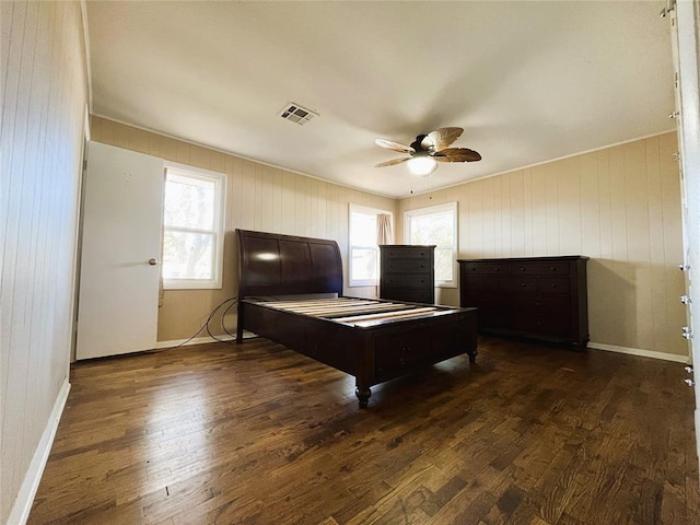 game room with ceiling fan, dark hardwood / wood-style flooring, and wooden walls