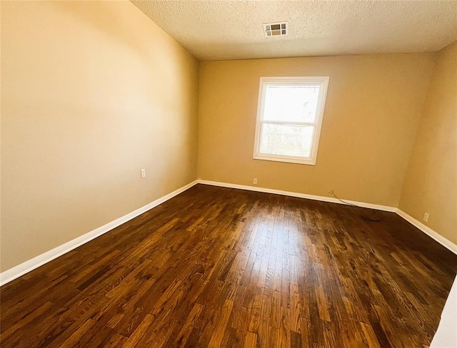 unfurnished room featuring a textured ceiling and dark wood-type flooring