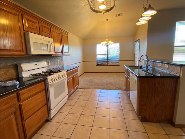 kitchen featuring sink, a chandelier, lofted ceiling, white appliances, and decorative light fixtures