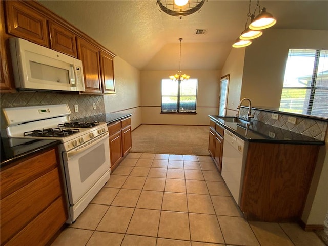 kitchen with white appliances, vaulted ceiling, a wealth of natural light, and sink