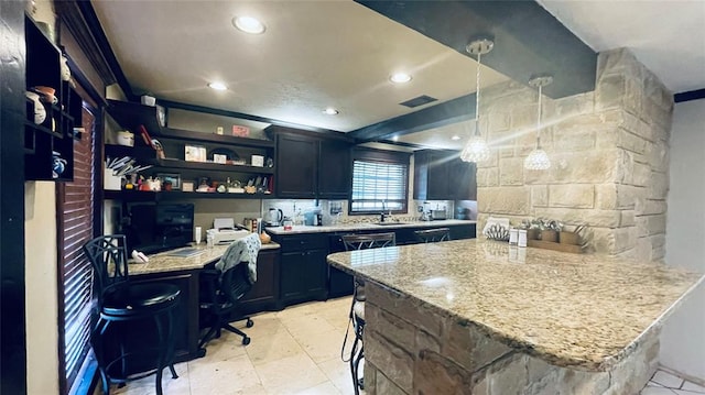 kitchen featuring a kitchen bar, kitchen peninsula, light stone counters, and pendant lighting