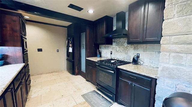 kitchen featuring beam ceiling, wall chimney exhaust hood, light stone counters, decorative backsplash, and black appliances