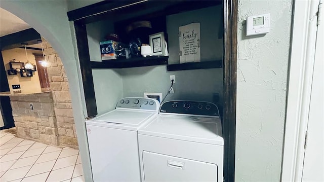 clothes washing area with tile patterned floors and washer and dryer