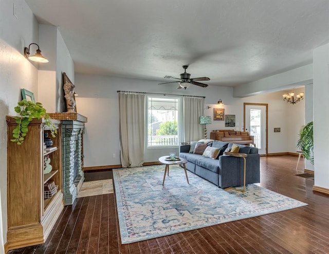 living room featuring ceiling fan with notable chandelier, dark hardwood / wood-style floors, and a wealth of natural light