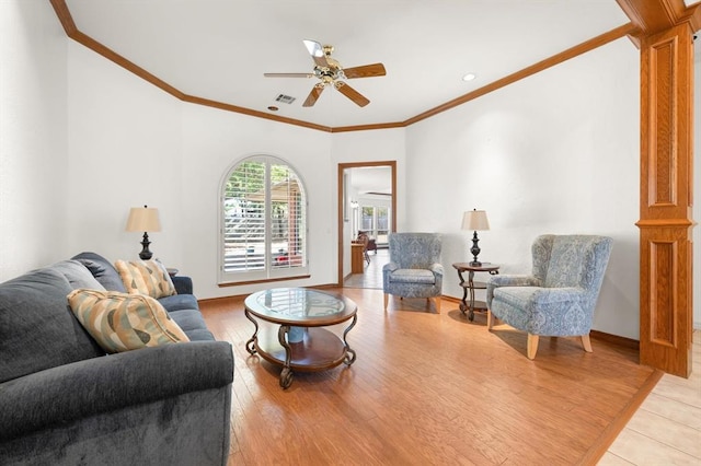 living area featuring light wood-style floors, baseboards, ornamental molding, and ornate columns