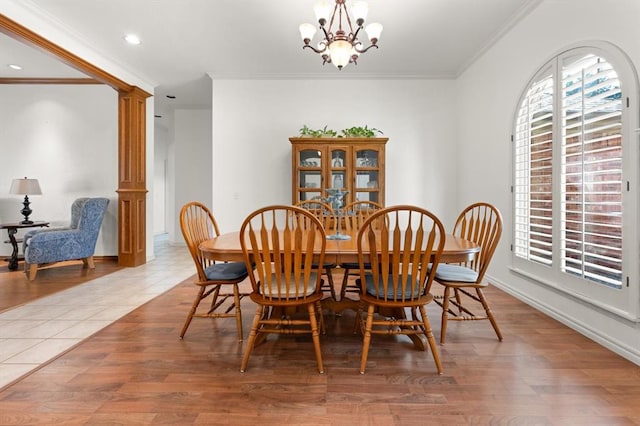 dining room with a healthy amount of sunlight, wood finished floors, and ornate columns