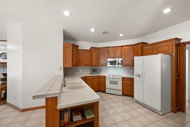 kitchen featuring open shelves, tasteful backsplash, brown cabinetry, a sink, and white appliances