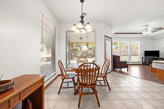 dining area featuring lofted ceiling, ceiling fan with notable chandelier, visible vents, and light tile patterned flooring