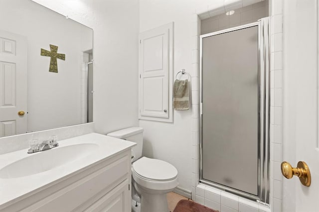 bathroom with a stall shower, vanity, and toilet