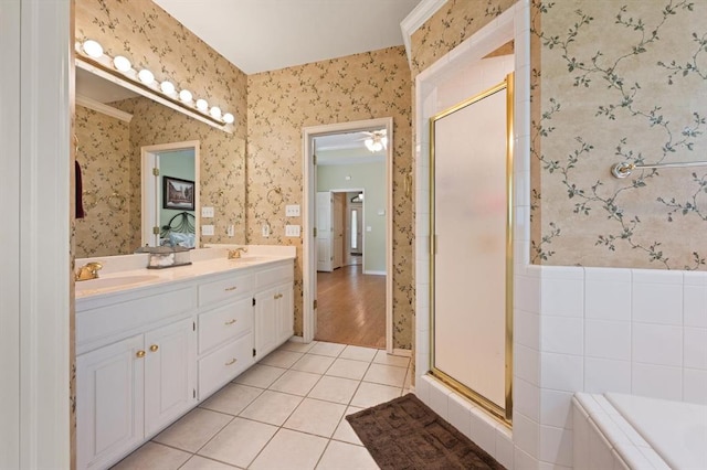 bathroom with tile patterned floors, a sink, a shower stall, and wallpapered walls