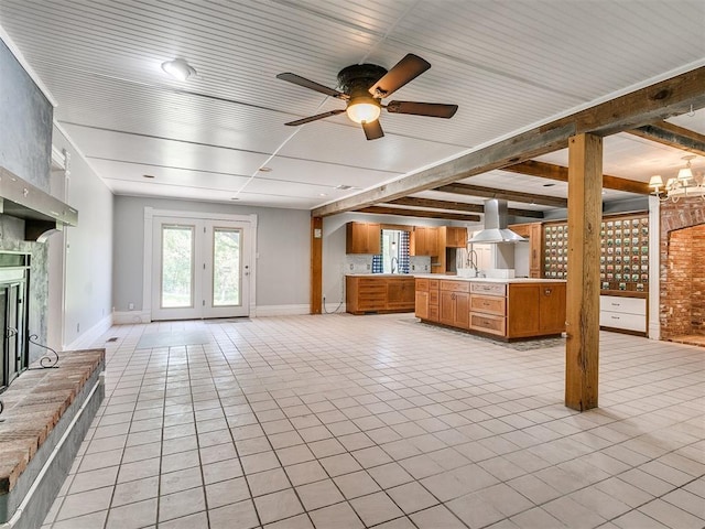 unfurnished living room featuring ceiling fan, sink, light tile patterned floors, and french doors