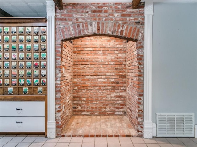 bathroom featuring brick wall and tile patterned flooring