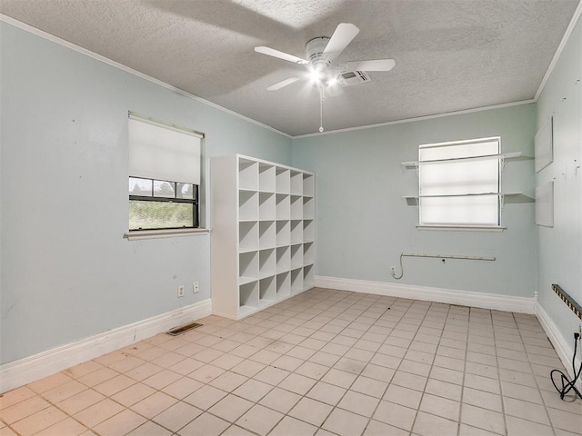 empty room with ceiling fan, a textured ceiling, and crown molding