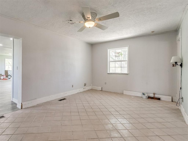 spare room featuring a textured ceiling, ceiling fan, crown molding, and plenty of natural light