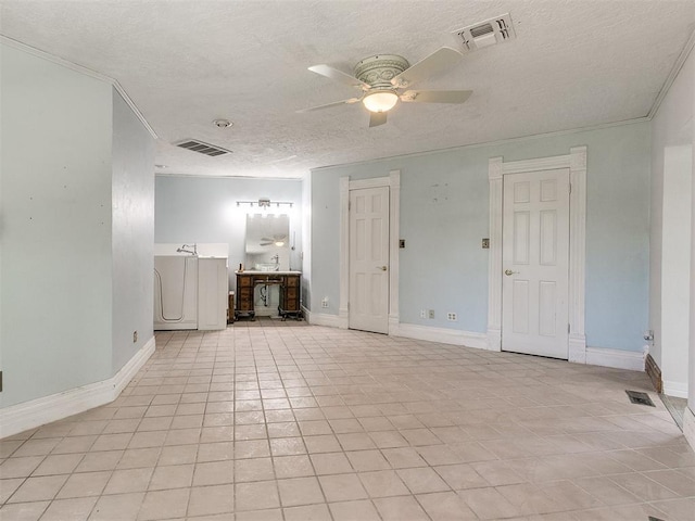 spare room with a textured ceiling, ceiling fan, light tile patterned floors, and ornamental molding