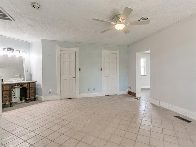 unfurnished bedroom with ceiling fan, light tile patterned floors, crown molding, and a textured ceiling