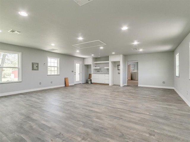 unfurnished living room featuring light wood-type flooring and washing machine and dryer