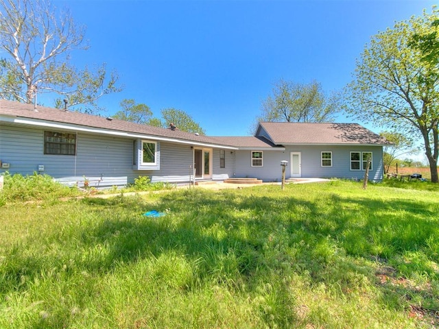 back of property with a yard and a patio