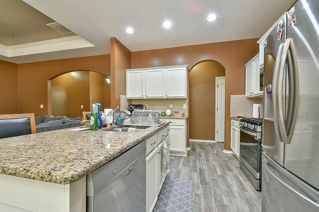 7301 Morning Song Dr, Oklahoma City, OK 73150 - kitchen featuring stainless steel appliances, arched walkways, backsplash, white cabinetry, and recessed lighting