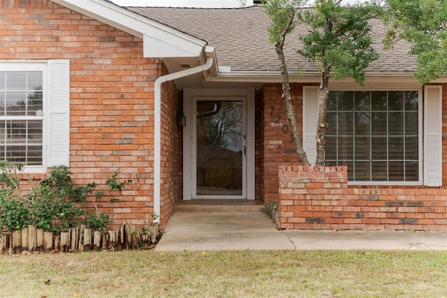 view of exterior entry with a yard