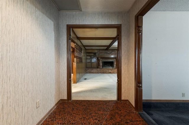 hallway with a textured ceiling and dark carpet