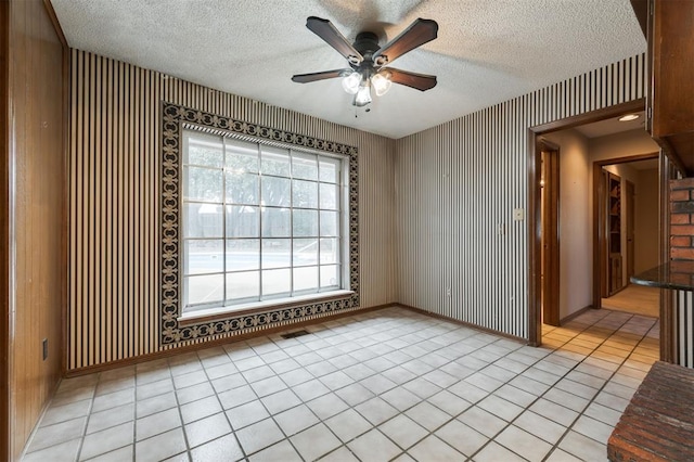 unfurnished room featuring light tile patterned floors, a textured ceiling, and ceiling fan