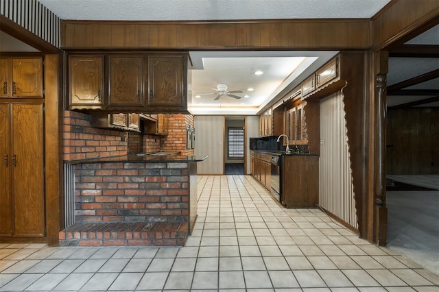 kitchen with ceiling fan, wood walls, and sink