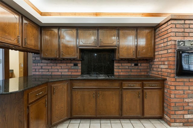 kitchen featuring gas cooktop, decorative backsplash, kitchen peninsula, dark stone countertops, and black oven